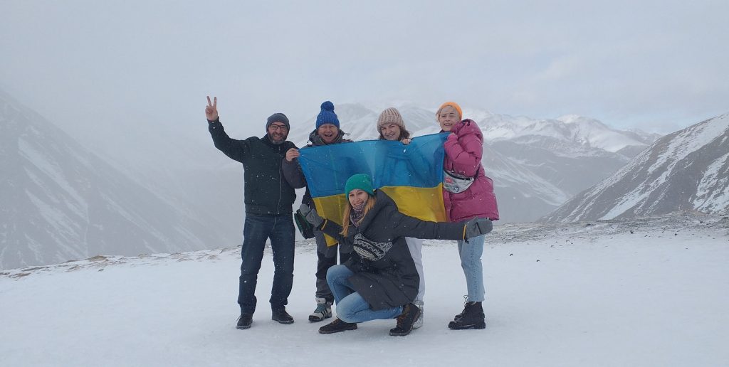 на вершине горы курорта Гудаури туристы с украинским флагом